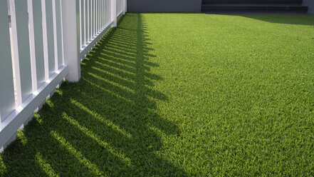 White fence with surrounding artificial grass